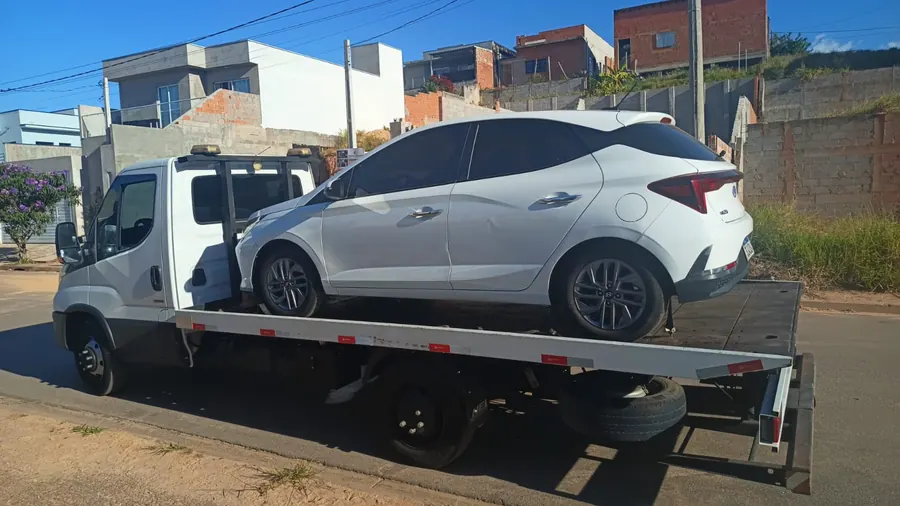Carro branco sobre a plataforma do guincho